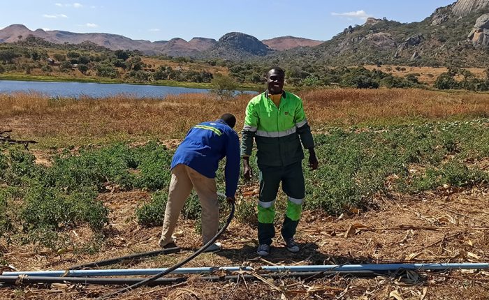 Men installing solar irrigation system on farm in Zimbabwe