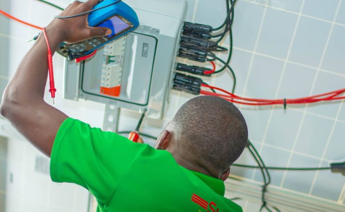 Man testing power capacity after installing solar system in Harare